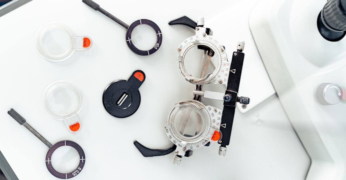 High-angle shot of optometry trial frames and lenses on a white surface.